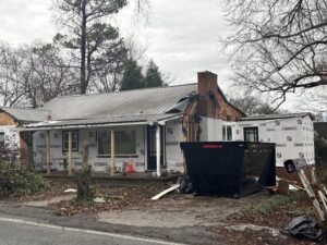 A dumpster placed at a house undergoing renovation for debris removal by Mobile Dumpster Solutions in Chattanooga, TN.