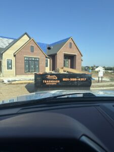 A TrashDash dumpster filled with construction debris at a new build house in West Haven, UT.