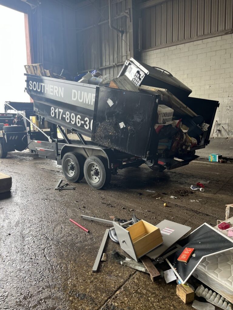 A dumpster being loaded with various household and construction junk for removal by NTX Haul Away Junk Removal in Fort Worth, TX.