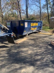 An AJ Carnevale Disposal dumpster being delivered to a paved driveway for a job in Hamilton, NJ