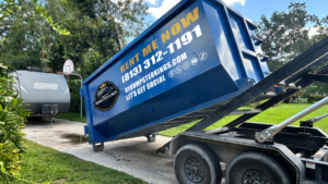 A blue dumpster being delivered for a junk removal job by R&Y Dumpster Kings in Tampa, FL.