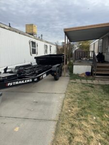 A DumpsterDash-LLC dumpster in Ogden, UT, being delivered to a mobile home for junk removal.
