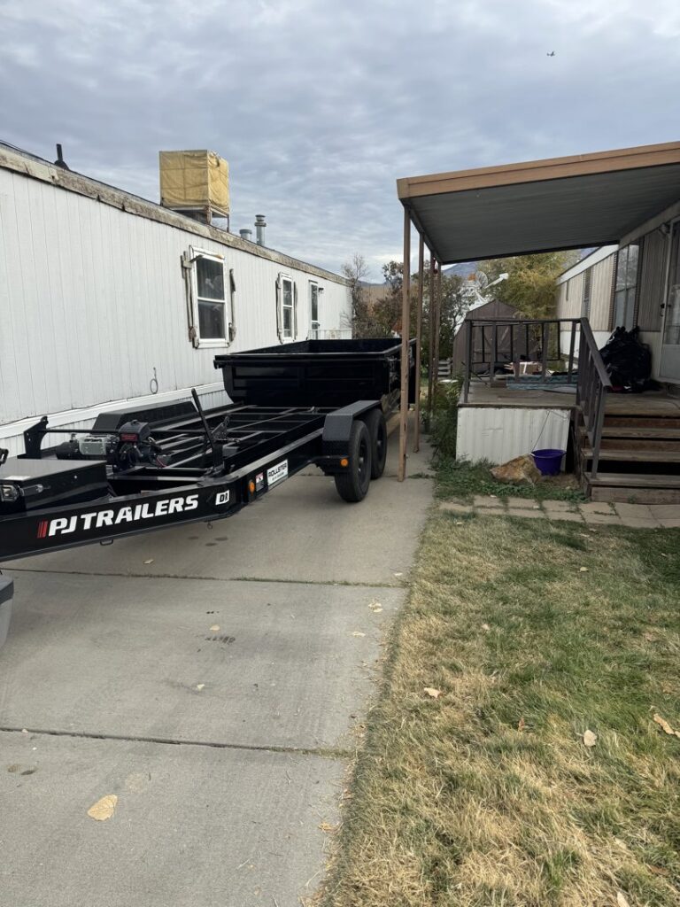 A DumpsterDash-LLC dumpster in Ogden, UT, being delivered to a mobile home for junk removal.