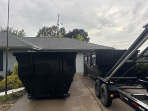 A Dump that Junk LLC team delivering or picking up a dumpster with a trailer in Mishawaka, IN.