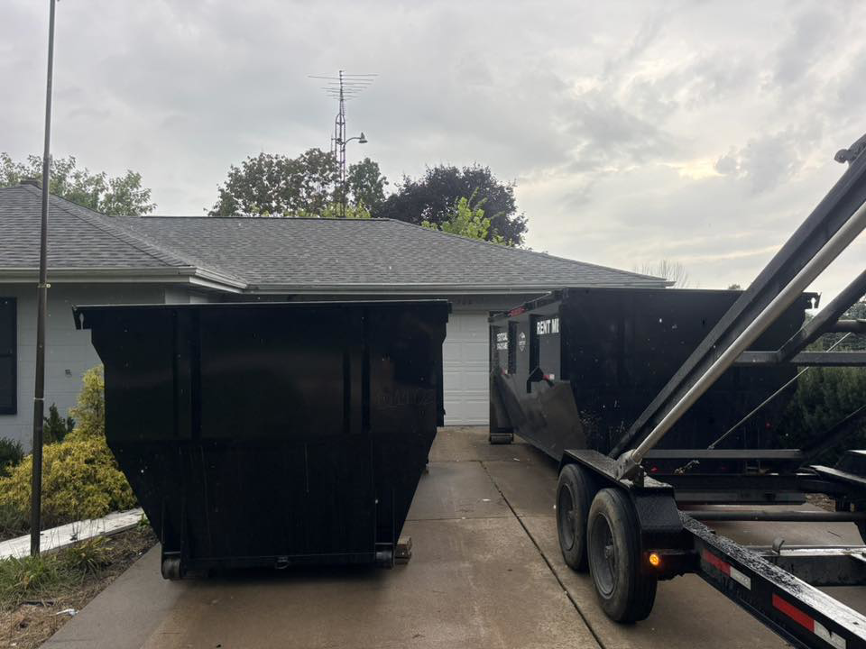 A Dump that Junk LLC team delivering or picking up a dumpster with a trailer in Mishawaka, IN.