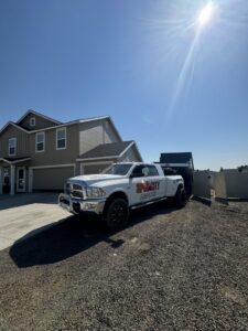 A SpudCity Dumpsters truck delivering a dumpster to a residential property in Caldwell, ID.