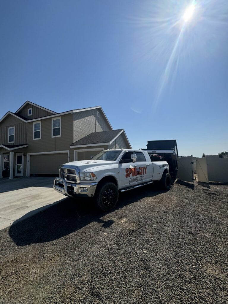 A SpudCity Dumpsters truck delivering a dumpster to a residential property in Caldwell, ID.