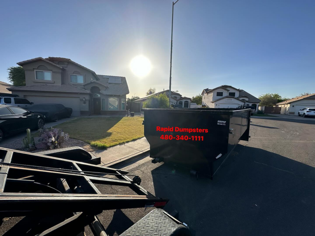 A Rapid Dumpsters container being delivered to a residential street for junk removal in Chandler, AZ.