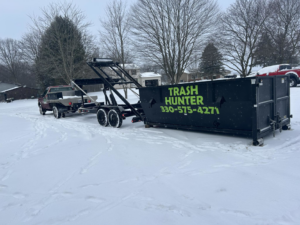 A Trash Hunter LLC dumpster being delivered on a snowy day in Hartville, OH, for general junk removal service.