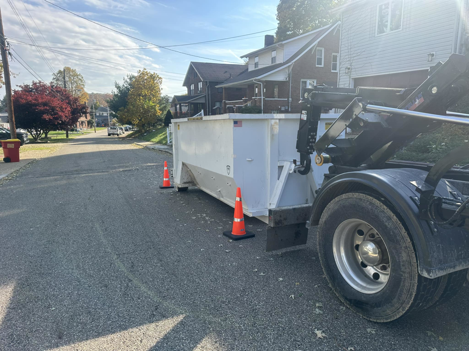 A white dumpster being delivered by White Dumpster for a junk removal job in Alliance, OH.