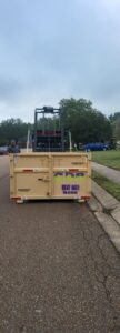 A dumpster from Curry Dumpster Rentals LLC being deployed on a residential street for junk removal in Southaven, MS.