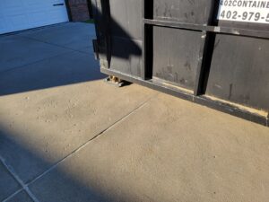 Close-up of a 402 Container dumpster with driveway protection in place for junk removal in Omaha, NE.