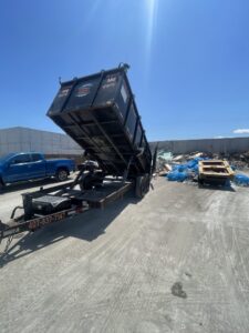 A dumpster trailer actively dumping construction debris at a disposal site for Trash N Go Dumpster's in Orlando, FL.