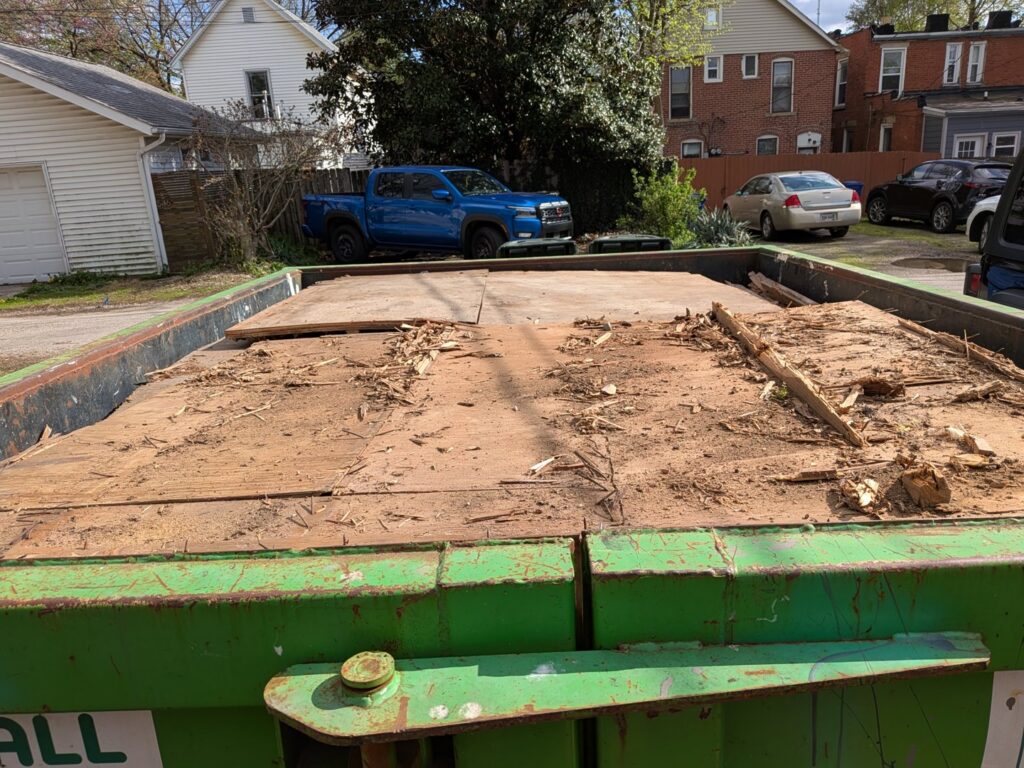 A Frog Hauling dumpster filled with wood debris from a general junk removal job in Columbus, OH.