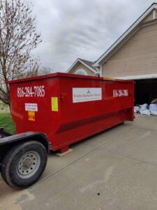 A red dumpster from Trinity Dumpster Rental LLC for a home cleanout project in Kansas City, MO.