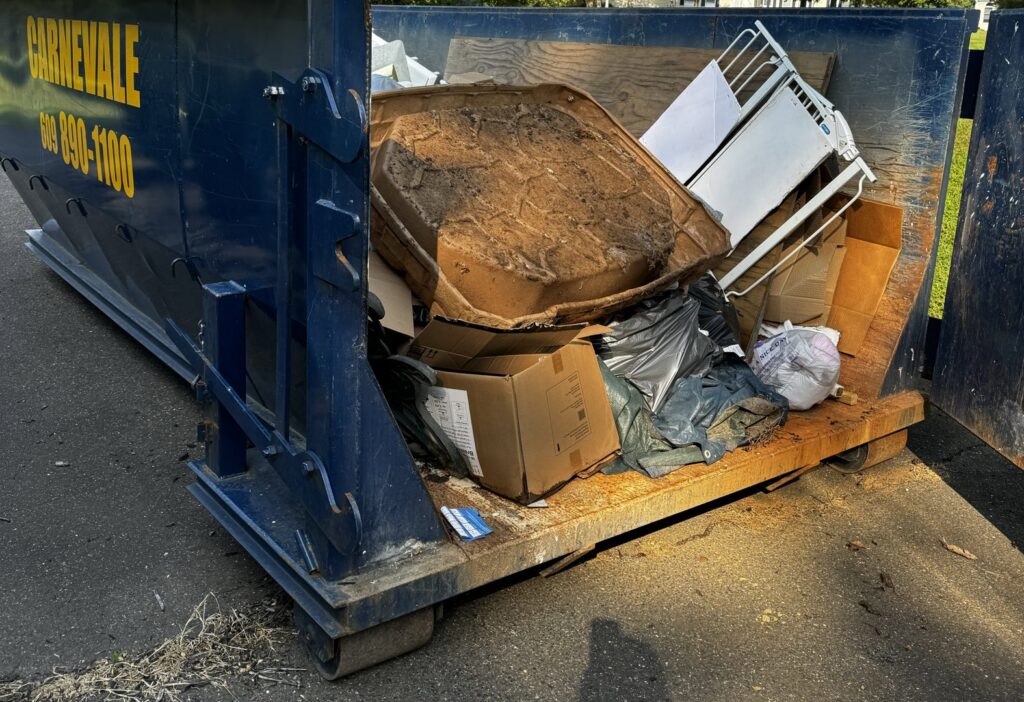 An AJ Carnevale Disposal dumpster filled with general junk and debris, ready for removal in Hamilton, NJ