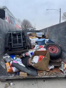 A large dumpster filled with household junk and debris for removal by Clean Slate Removal in Grand Island, NE.