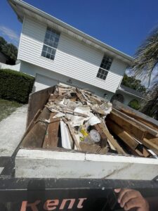 A dumpster trailer filled with various construction waste and debris for junk removal by Trash N Go Dumpster's in Orlando, FL.