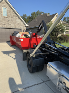 A dumpster full of household junk being removed by Boxx Boss Solutions from a residential property in Bossier City, LA.