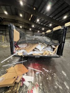A Trademark Dumpsters trailer overflowing with various junk and debris from a completed removal project in Wilmington, DE.