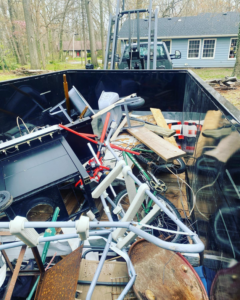 A large dumpster filled with various household and construction junk items, ready for removal by trash_tiger in Canton, OH.