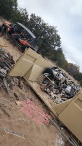 A Bin Suave LLC dumpster filled with mixed junk and debris on a job site in Espanola, NM.