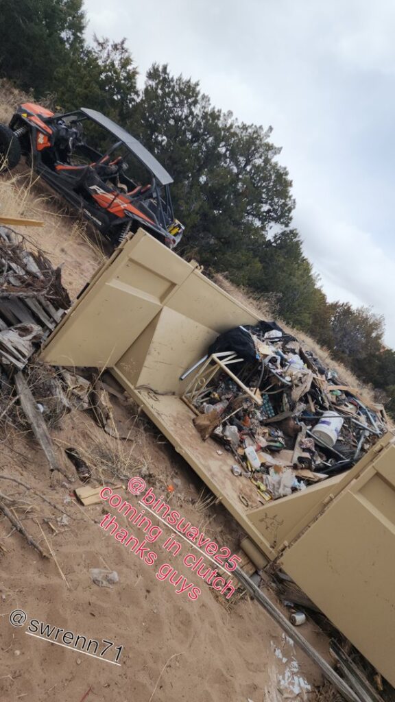 A Bin Suave LLC dumpster filled with mixed junk and debris on a job site in Espanola, NM.