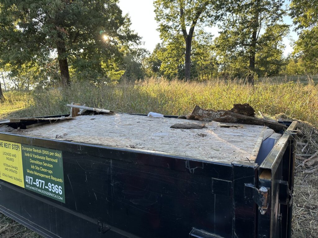 A Waste Walkers Dispatch dumpster filled with wood debris and construction materials in Springfield, MO.