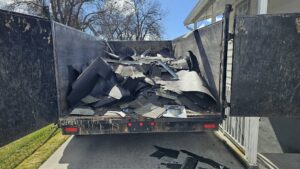 A dumpster full of old roofing materials and debris from a job by Proline Roofing in Shipshewana, IN.