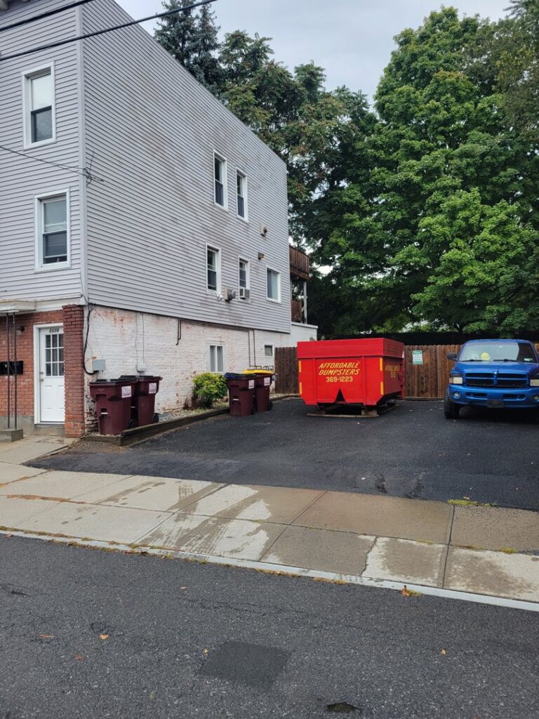A red dumpster from Affordable Dumpsters placed in a parking lot for commercial junk removal in Watervliet, NY.