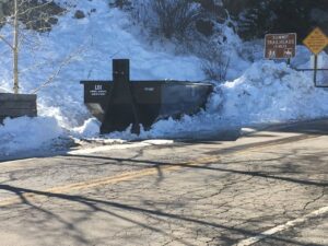 A Liberty Disposal, Inc. dumpster partially buried in snow next to a road, indicating a service location in Tucson, AZ.