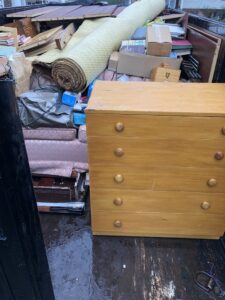 A Trademark Dumpsters trailer loaded with old furniture and various junk for removal from a property in Wilmington, DE.