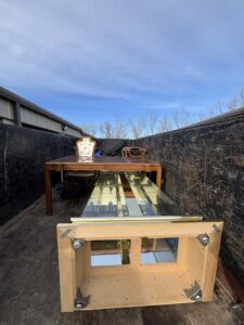 A large dumpster or truck bed loaded with various furniture pieces, demonstrating a junk removal job by Richie Bros Junk Removal in Urbandale, IA.