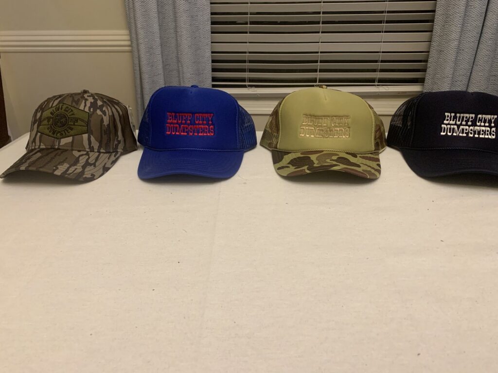 A Bluff City Dumpsters roll-off dumpster placed on a paved area with trees in the background in Memphis, TN.