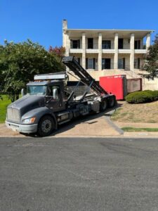 A redbox+ truck picking up a dumpster from a large residential property for redbox+ Dumpsters of Greater Austin in Austin, TX