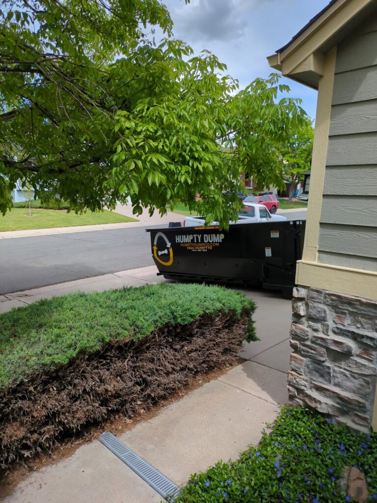 A Humpty Dump Roll-Offs & Dumpsters dumpster placed in a residential driveway in Commerce City, CO.