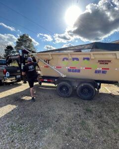 A dumpster from Curry Dumpster Rentals LLC placed in a residential driveway, ready for junk removal in Southaven, MS.