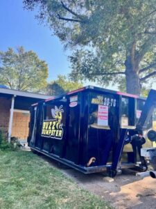 A Buzz Dumpster & Junk Removal container placed in a residential yard for junk removal in Troy, MO.