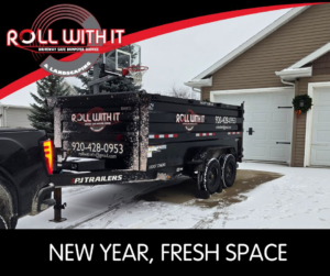 A Roll With It dumpster trailer parked in a snowy residential driveway, ready for junk removal service in Appleton, WI.