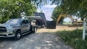 An O'Lakes Dumpster Rental truck and excavator on site for debris removal in Lexington, KY.