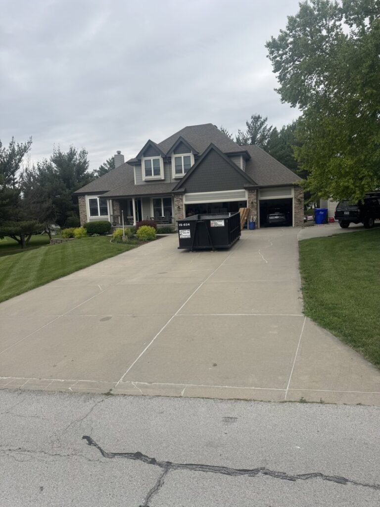 A 402 Container dumpster placed on a residential driveway for a home cleanup project in Omaha, NE.