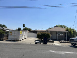 A roll-off dumpster placed in a residential driveway for junk removal by Waste Removal and Recycling, Inc. in Sacramento, CA.