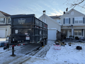 A dumpster trailer parked in front of a house for roofing debris removal by Anywhere Dumpster Rental in Naperville, IL.