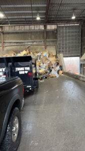 A Greybeard Dumpster Rentals trailer at a transfer station, unloading junk and debris in Morgantown, WV.