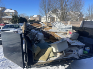 A dumpster trailer filled with various junk items, including a bathtub and construction debris, by Redline Hauling in Westerville, OH.