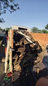 A Haul-Away Junk Removal and Dumpster Rental trailer loaded with wooden debris from a cleanout project in Overland Park, KS.