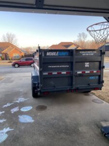 A Mobiledumps trailer parked in a residential driveway, ready for junk removal in Rogers, AR.