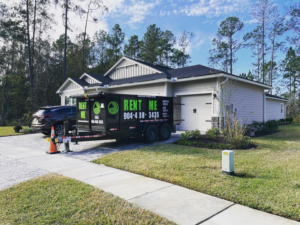 A dumpster trailer from Duval Dumpster Rentals, LLC in Jacksonville, FL, parked in a residential driveway for general junk removal services.