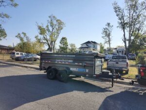 A Mobiledumps trailer parked on a residential street for junk removal services in Rogers, AR.