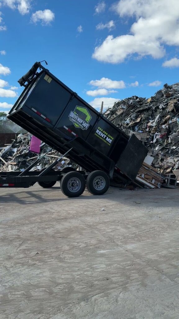 A Driveway Safe Dumpster Rental trailer unloading debris at a landfill, part of a junk removal job in Fort Lauderdale, FL.